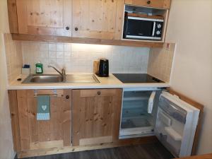 a small kitchen with a sink and a microwave at Résidence Les Alpages 4 étoiles - Appartement 4 personnes - Piscine, Hammam, Sauna, Jacuzzi - ValCenis 73480 in Lanslebourg-Mont-Cenis