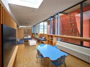 Zimmer mit einer Kletterwand, einem Tisch und Stühlen in der Unterkunft Youth Hostel Echternach in Echternach