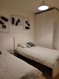 a bedroom with two beds and a white cabinet at L'univers au blanc. in Strasbourg