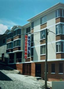 a building with a hotel sign in front of it at Hotel Moderno Coroico in Coroico