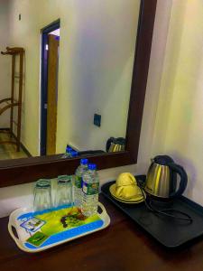 錫吉里亞的住宿－Sigiri Sunrise Villa，一个带镜子的柜台和一个带水瓶的托盘