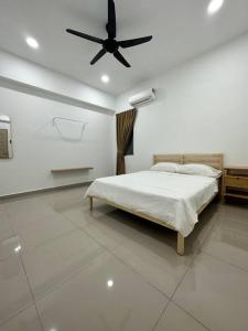 um quarto com uma cama e uma ventoinha de tecto em Grove Forest em Sitiawan