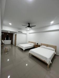 Duas camas num quarto branco com tecto em Grove Forest em Sitiawan