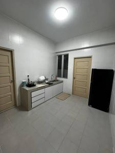 uma cozinha com 2 portas castanhas e um piso de azulejo branco em Grove Forest em Sitiawan