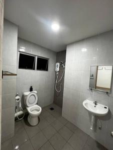 uma casa de banho com um WC e um lavatório em Grove Forest em Sitiawan