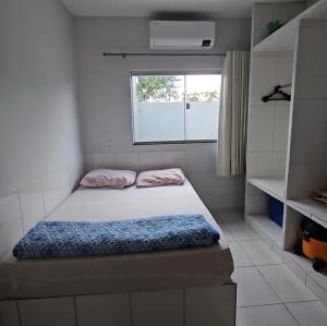 a small bedroom with a bed and a window at Casa em Caldas Novas in Caldas Novas