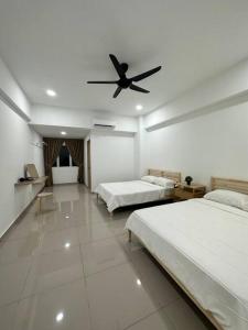 um quarto com 2 camas e uma ventoinha de tecto em Grove Forest em Sitiawan