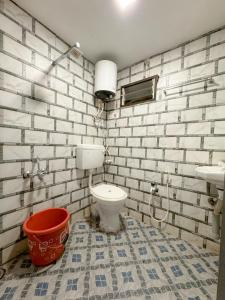 a bathroom with a toilet and a bucket at Riverfront Resort Dandeli in Dandeli