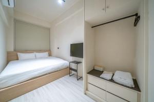 台南的住宿－Times Inn - Tainan，一间带床和电视的小卧室