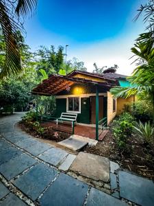 a house with a bench in front of it at Riverfront Resort Dandeli in Dandeli