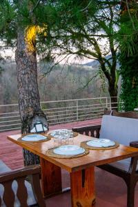 a wooden table on a deck with a tree at Kaltur boutique otel in Yalova