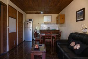 a living room with a couch and a table and a kitchen at Mi casa es tu casa in Melo