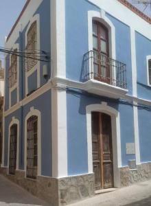 um edifício azul e branco com uma varanda e portas em Tu casa em Almeria