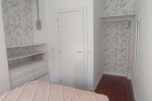 um quarto branco com uma cama e um closet em Tu casa em Almeria