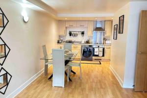 a kitchen with a table and a dining room at Urban Chic: 2 Bedroom Apartment in City Centre + FREE Parking in Birmingham