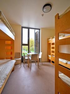 a bedroom with bunk beds and a table and chairs at Youth Hostel Echternach in Echternach