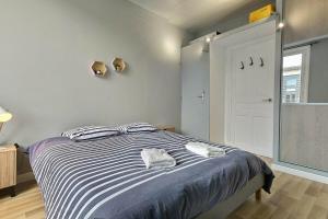 a bedroom with a bed with two towels on it at Danton | Spacieux | WiFi | Parking | Proche Centre in Troyes