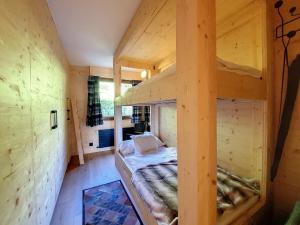 ein Schlafzimmer mit Etagenbetten in einem Holzzimmer in der Unterkunft La Ruinette - Cosy 2 Bed With Stunning Views in Verbier
