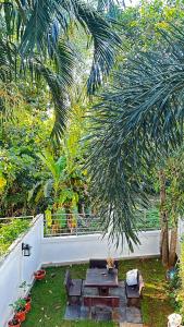 eine Terrasse mit einem Picknicktisch und einer Palme in der Unterkunft AURIFLEX HOUSE in Krabi