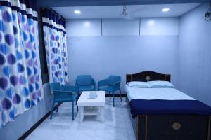 Habitación hospitalaria con cama, mesa y sillas en EAGLE NEST FAMILY HOUSE, en Bhuj