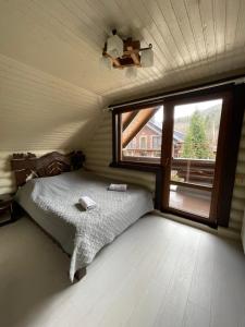 - une chambre avec un lit et une grande fenêtre dans l'établissement Goral cottage in Migovo, à Myhove