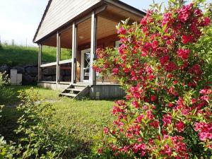 dom z różowymi kwiatami przed nim w obiekcie Camping Onlycamp Les Petites Roches w mieście Saint-Hilaire