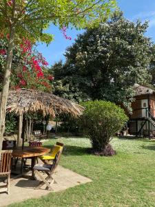 Villa -Guesthousejane & Apartments في نيفاشا: طاولة نزهة ومظلة القش في الفناء