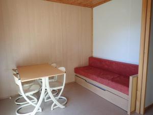 mały pokój z czerwoną ławką i stołem w obiekcie Camping Onlycamp Les Petites Roches w mieście Saint-Hilaire +16 zdjęć