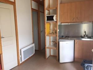mała kuchnia z lodówką i zlewem w obiekcie Camping Onlycamp Les Petites Roches w mieście Saint-Hilaire