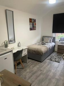 a bedroom with a bed and a desk and a desk at Abington Park 5 Bedrooms with en-suite in Spinney Hill +19 photos