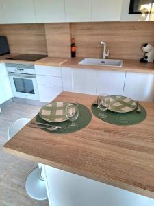 una cocina con una mesa con dos platos y vasos en Vera Sol y Mar - Naturist Zone, en Playas de Vera