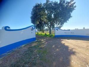 a blue and white fence with a tree in the background at Quinta do Mocho by Portus Alacer in Arcos