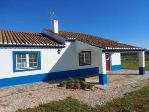 Quinta do Mocho في Arcos: البيت الأزرق والأبيض مع نباتات الفخار