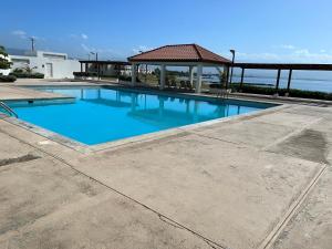 a large blue swimming pool with a gazebo at Beach access apartment in Portmore