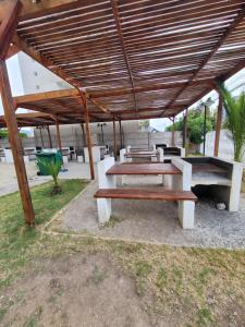 une table de pique-nique et des bancs sous un toit en bois dans l'établissement Depto. Frente a playa y supermercado, à Coquimbo