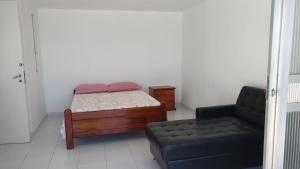 a small bedroom with a bed and a couch at Apto Temporada Cabo Frio in Cabo Frio