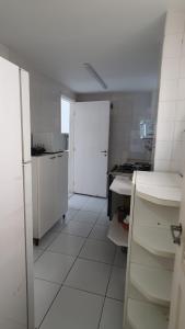 a kitchen with white appliances and a white floor at Apto Temporada Cabo Frio in Cabo Frio