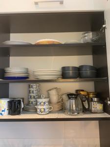 a kitchen shelf with plates and utensils at Centrum Apartment Lipowa 12 in Białystok