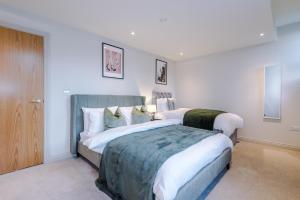 a bedroom with a large bed with white sheets at Designer Central Leeds Home by PureStay sleeps 5 in Leeds