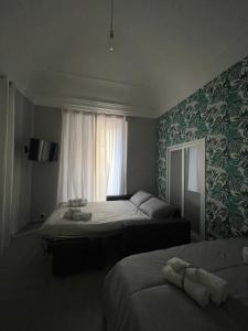 een slaapkamer met twee bedden en een raam bij Riccioli Home in Catania