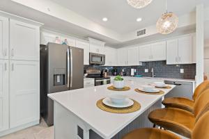 a kitchen with white cabinets and a refrigerator at Serenity Haven - Storey Lake #701 by Shine Villas in Kissimmee