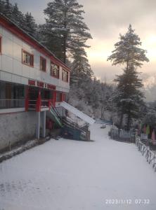 a building with snow in front of it at Manikarn Resort in Joshīmath