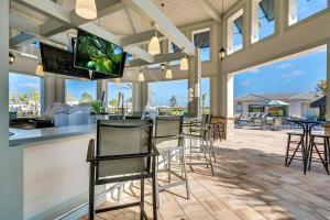 a patio with chairs and a bar with a flat screen tv at Serenity Haven - Storey Lake #701 by Shine Villas in Kissimmee