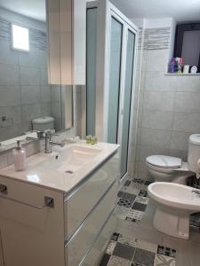een witte badkamer met een wastafel en een toilet bij Riccioli Home in Catania +16 foto's