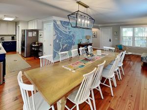 a kitchen and dining room with a large wooden table and chairs at Nautical Watch in Tybee Island