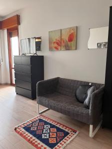 sala de estar con sofá y alfombra en Casa Udine Charme 5 posti letto, 