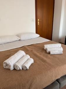 a bed with three towels sitting on top of it at Casa Udine Charme 5 posti letto 
