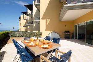 a wooden table and chairs on a patio at 2Bdr Ground Floor Condo With Terrrace! in Palm-Eagle Beach