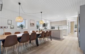 cocina y comedor con mesa y sillas en Awesome Home In Ringkbing With 4 Bedrooms, Sauna And Indoor Swimming Pool, en Søndervig