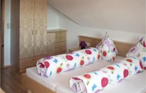 a bedroom with two beds with floral pillows at Amazing Apartment In Pllau Am Greim With 4 Bedrooms And Wifi in Sankt Peter am Kammersberg